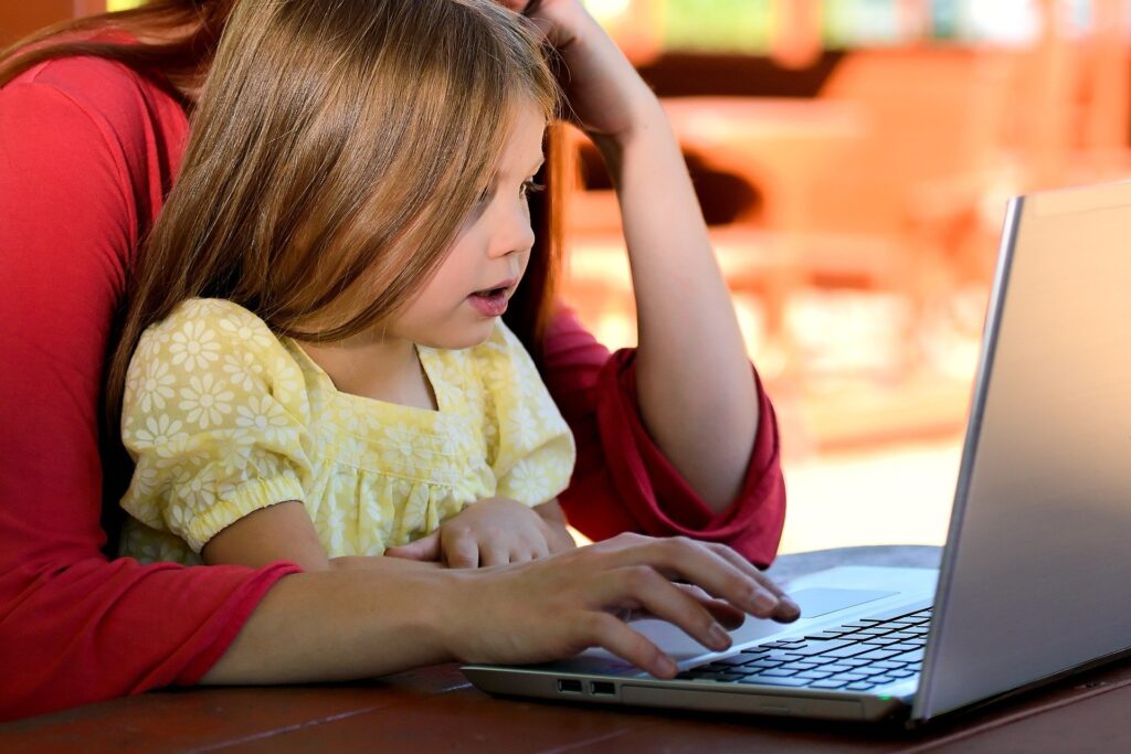 Child at laptop with mother