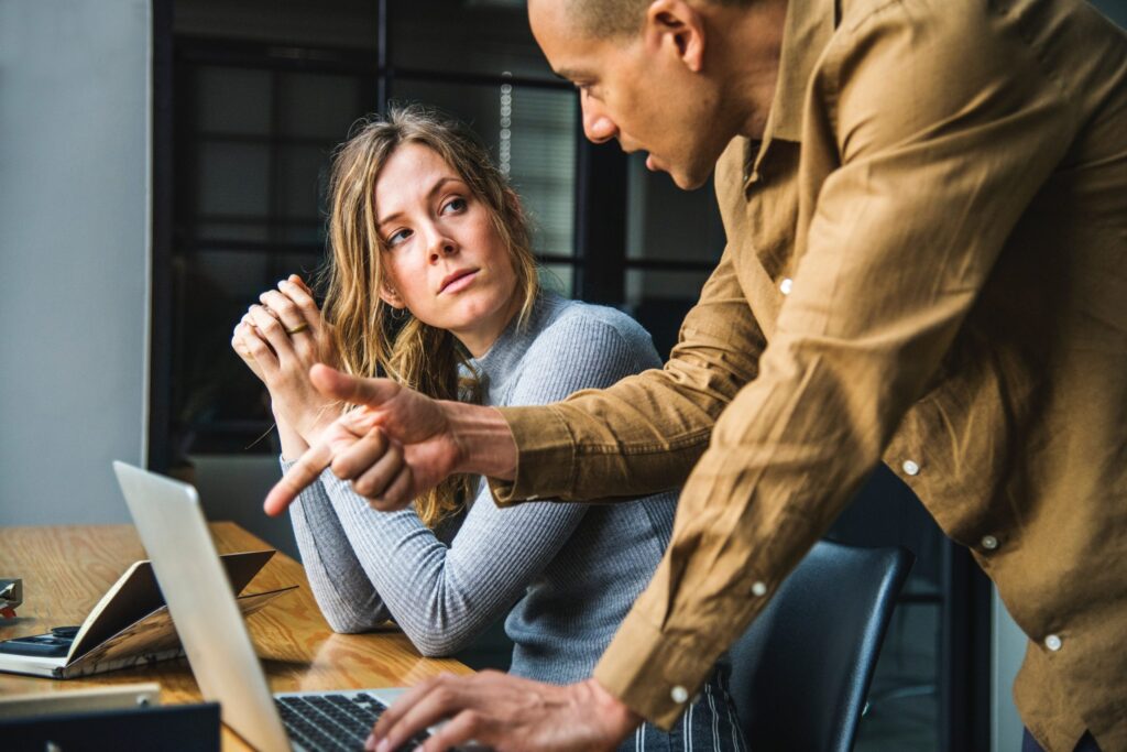 Two adults discussing over laptop