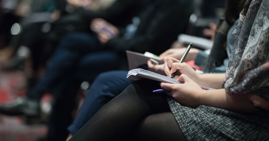 People writing in audience