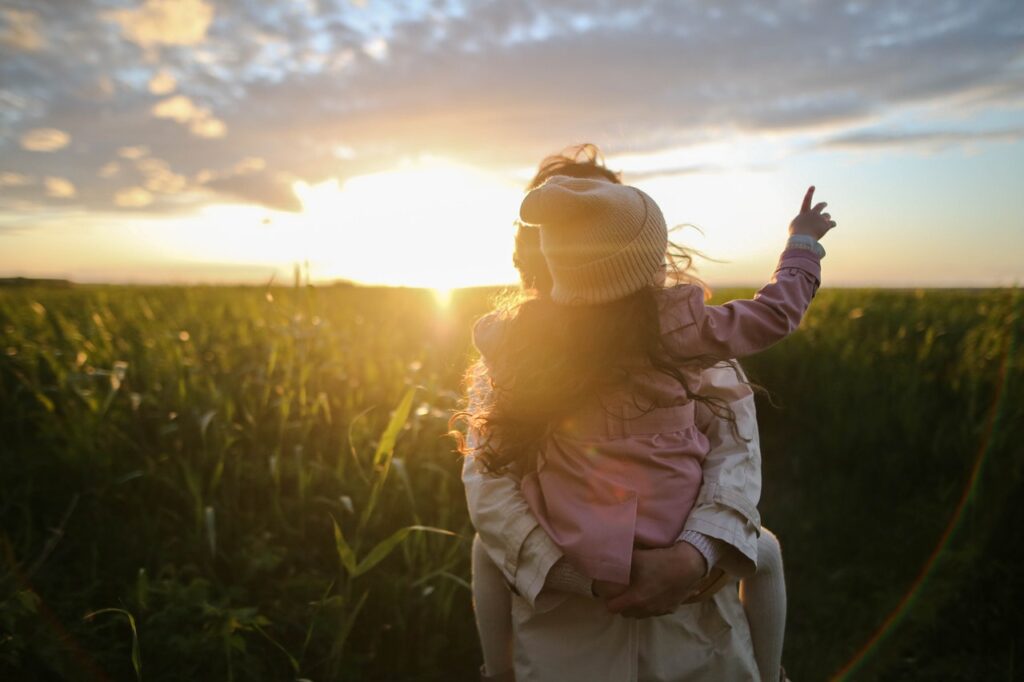 Mother and young child outside at sunset