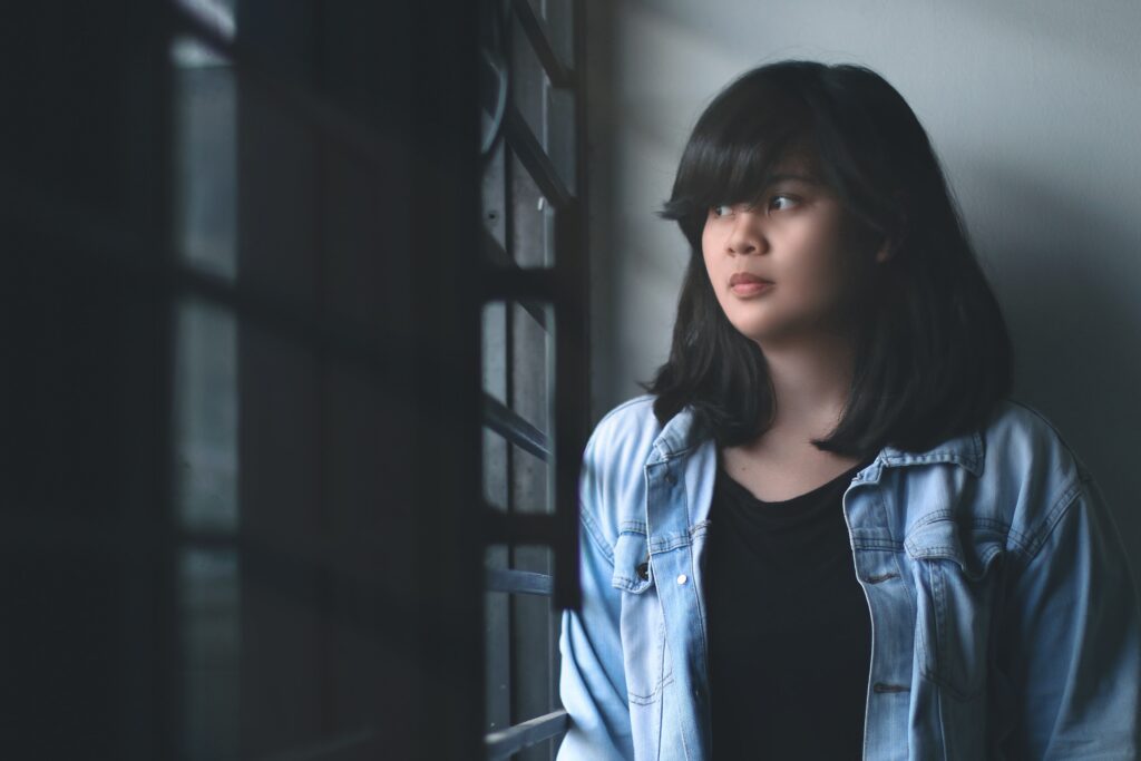 Young person looking out a window