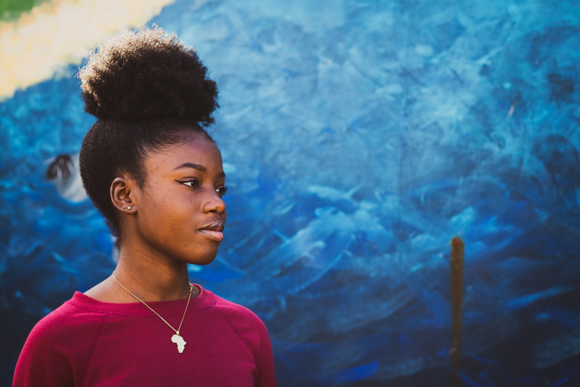 Young person outside against a blue wall