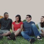 Group of young people sitting on grass