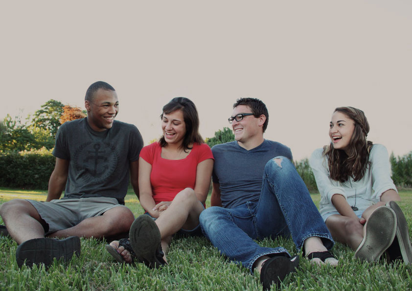 Group of young people sitting on grass