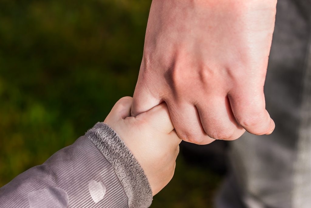 Child holding adult's finger