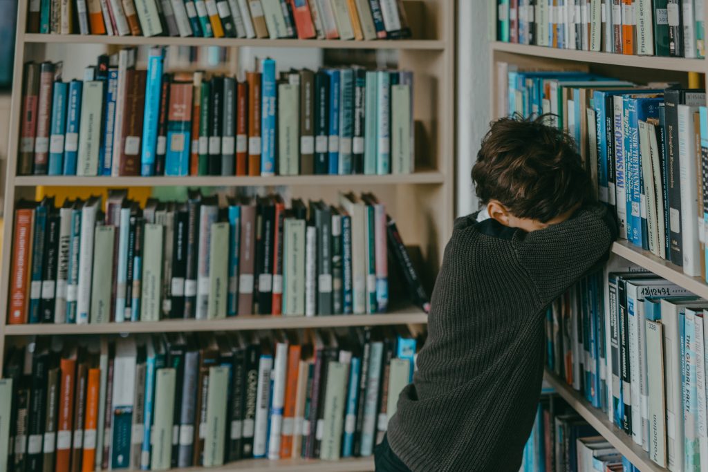 Child against a book shelf