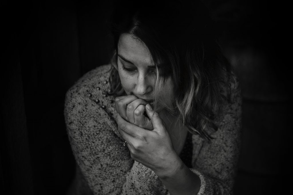 Young woman biting her nails