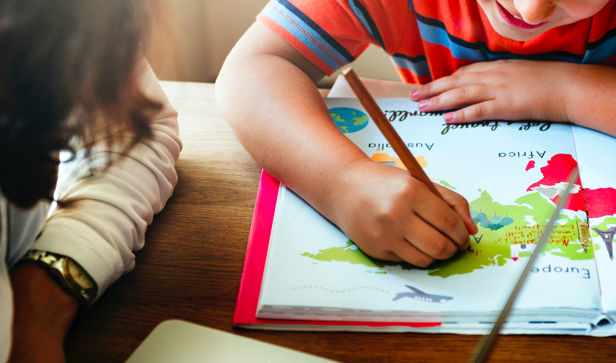 Adult and child working on a geography book